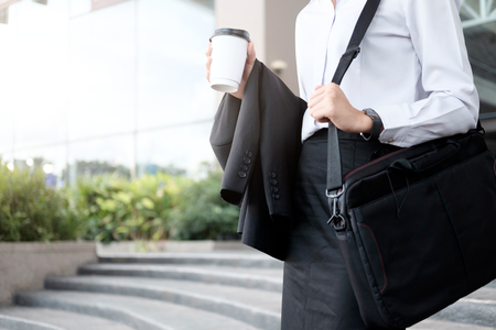 Business woman walking drinking coffee. Lawyer professional or similar walking outdoors happy holding disposable paper cup. Businesswoman smiling happy outside.の写真素材