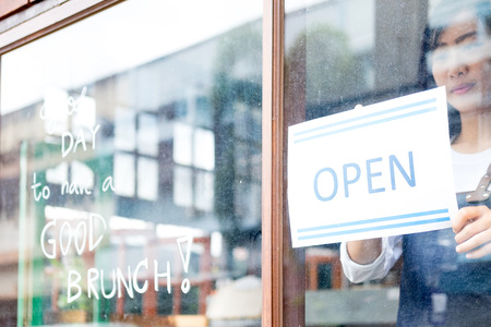 Open Small business: Happy owner of a cafe. Young startup owner small cafe shop