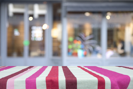Empty wooden table for present product on coffee shop or soft drink bar blur background with bokeh...