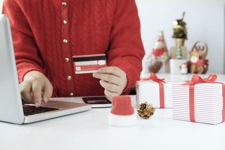 Woman holding credit card and doing shopping online. New year, Christmas gift shopping.の写真素材