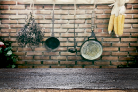 Empty wooden table for present product on vintage kitchen utensils blur background with bokeh image.の写真素材