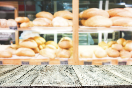 Empty wooden table space platform and blurred bakery shop background for product display montageの写真素材