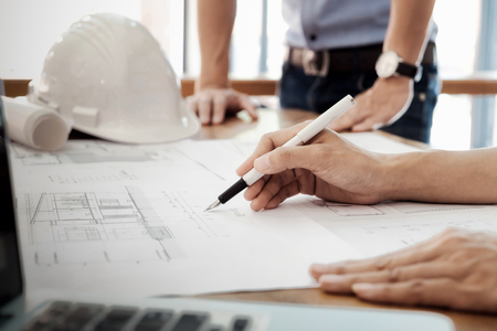 Image of engineer meeting for architectural project working with partner and engineering tools on workplace.の写真素材