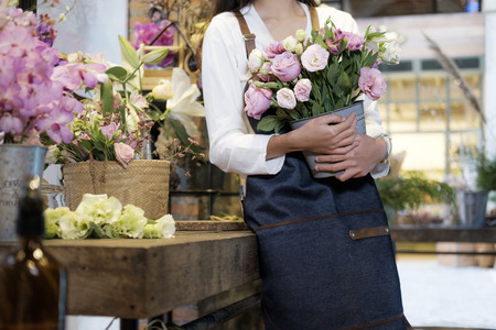 Confident Young Business Owner of Flower Shop Store holding flowerの写真素材