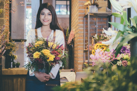 Confident Young Business Owner of Flower Shop Store holding flowerの写真素材