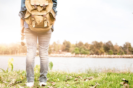Young woman Traveler with backpack relaxing outdoor. Summer vacations and Lifestyle hiking concept. Retro filter effect, selective focusの写真素材
