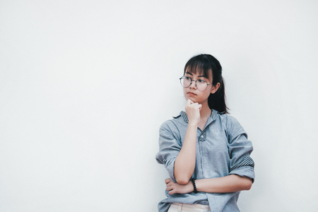 Young girl dreaming thinking looking in side over white background.の写真素材