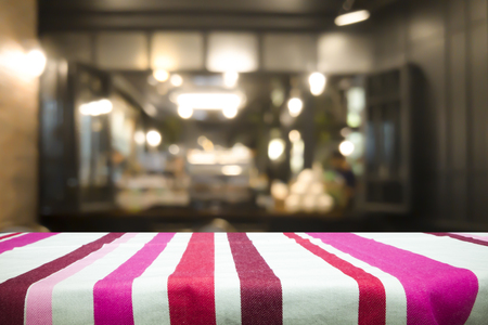 Empty wooden table for present product on coffee shop or soft drink bar blur background with bokeh image.の写真素材