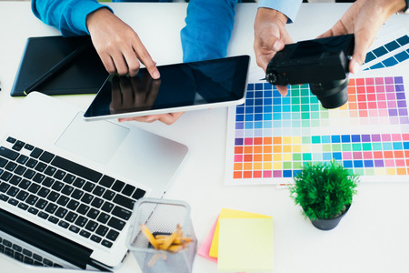 Graphic designer and Photographer working on computer and used graphics tablet.