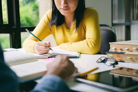 Learning, education and school concept. Young woman and man studying for a test or an exam. Tutor...