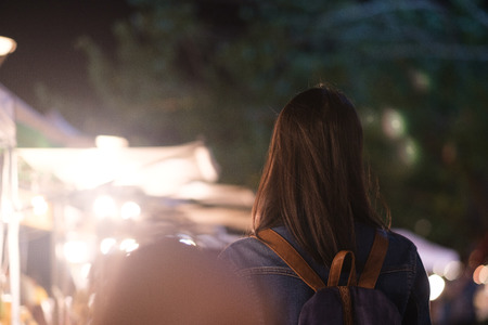Young traveller woman walking on city street at night.の写真素材
