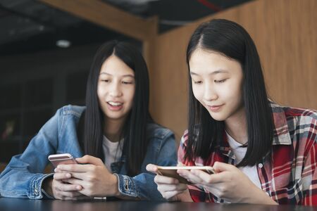 Teenage student using digital mobile phone online chat.の写真素材