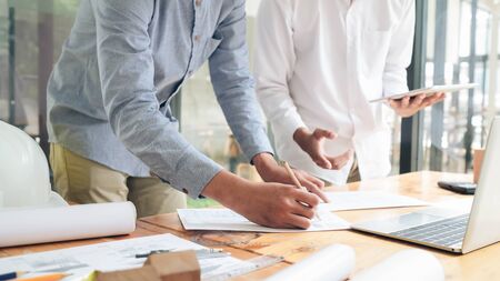Image of engineer meeting for architectural project working with partner and engineering tools on workplace.の写真素材