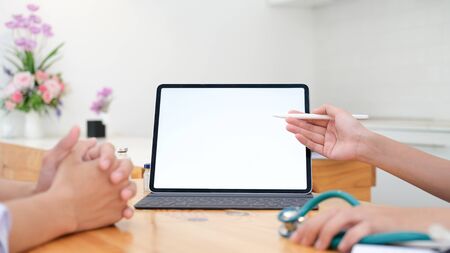 Doctor using tablet discussion something with patient. Health care , Hospital and Doctor concept. Copy space of blank computer and tablet screen.の写真素材
