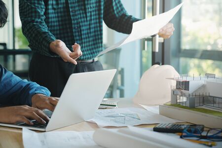 Image of engineer meeting for architectural project working with partner and engineering tools on workplace.の写真素材