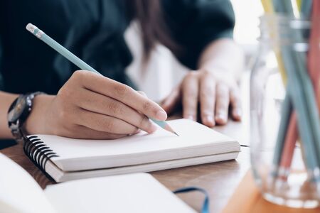 Close up female hands with pen writing on notebook. Education concept.