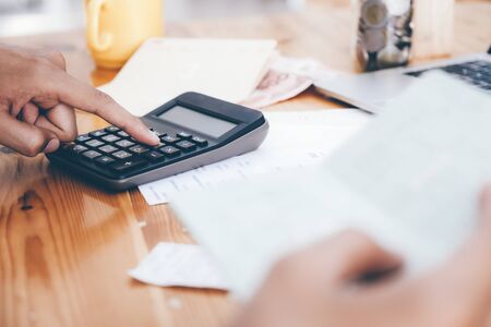 Finances Saving Economy concept. Accountant or banker calculate the cash bill.の写真素材
