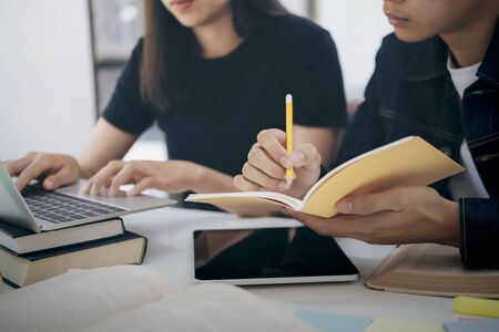 Learning, education and school concept. Young woman and man studying for a test or an exam. Tutor...