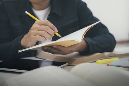 Close up hands with pen writing on notebook. Education concept.