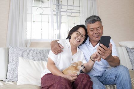 Happy senior couple  online video call with their family via cellphone.の写真素材