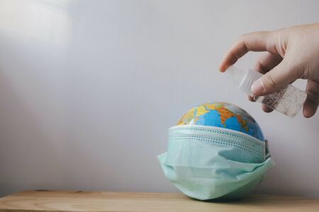 World globus with green medical mask on it. Coronavirus epidemic concept. Concept for world wide spread of Coronavirus desease.の写真素材