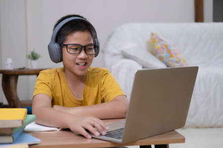 Young collage student using computer and mobile device studying online. Education and online...