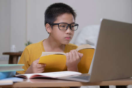 Young collage student using computer and mobile device studying online. Education and online...