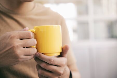 Close up man hands holding a cup of coffee.