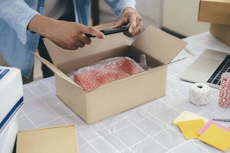 Online small business owner. Young startup entrepreneur online small business owner working at home, packaging and delivery situation. の写真素材