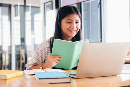 Cheerful child excited using computer for online learining. Online education and self study and...