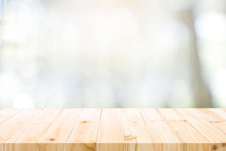 Empty wooden table for present product on coffee shop or soft drink bar blur background with bokeh...