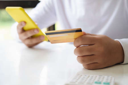 Hand holding credit card and mobile phone, The credit card prepare for customer and entrepreneur using for online shopping.の写真素材