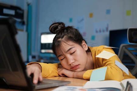 Overnight working at home office. woman working over time.の写真素材