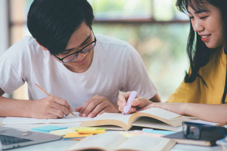 Young students campus helps friend catching up and learning.の写真素材