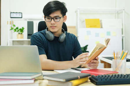 Young man study in front of the laptop computer at homeの写真素材