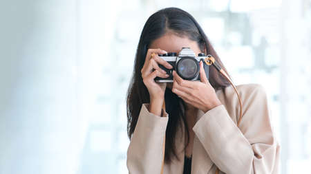 Young asian woman is a professional photographer with modern photo camera.の写真素材