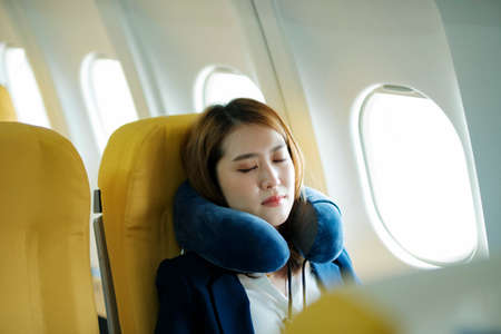 Business woman In a plane, sleeping on the plane on the go.の写真素材