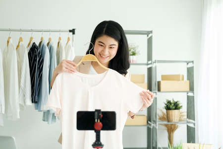Businesswoman giving important pieces of advice while streaming video for womens clothing.の写真素材