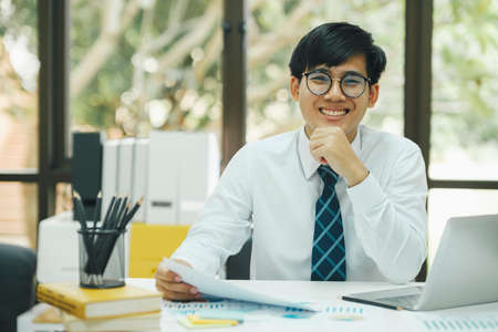 Happy asian businessman about investment market data analysis.の写真素材