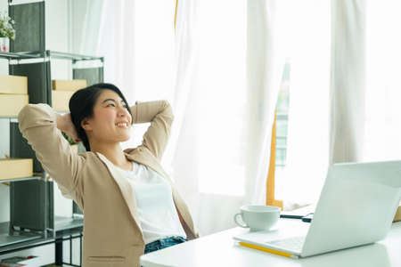 Happy young asian female freelan sit in online clothing store.の写真素材