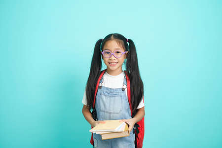 Close-up kid students girl smiling holding book, going to school.