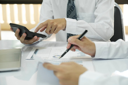 Asisan businessman teamwork meeting and discussing the investment data and report graph on laptop and calculator Teamwork meeting working concept.の写真素材