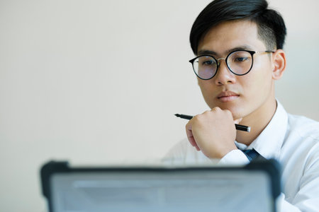 Businessman looking at online marketing research report. Business is analyzing statistical data in...