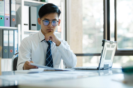 Businessman looking at online marketing research report. Business is analyzing statistical data in charts and developing growth investment strategy.の写真素材