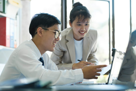 Close up businesspeople or colleagues are working together on investment project, discussing, sharing ideas, planning, and analyzing the business strategy and finance using laptop computer.の写真素材