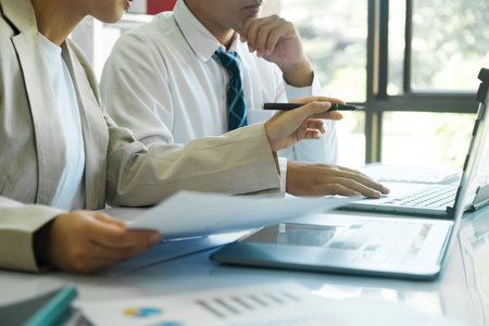 close up businesspeople or colleagues are working together on investment project, discussing, sharing ideas, planning, and analyzing the business strategy and finance using laptop computer.の写真素材