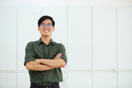 Portrait of a young asian confident man arms crossed smiling at camera.の写真素材