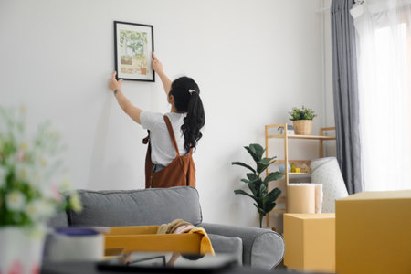 Young Asian woman decorating new home while moving in to new house or apartment.の写真素材
