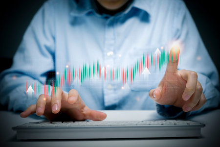 Man typing and pointing to holographic trading chart.の写真素材