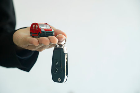 Close up hand of businessman, car dealer giving new car key to customer.の写真素材